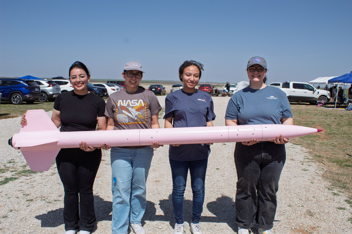 The Roadrunner Rocketeers holding their rocket